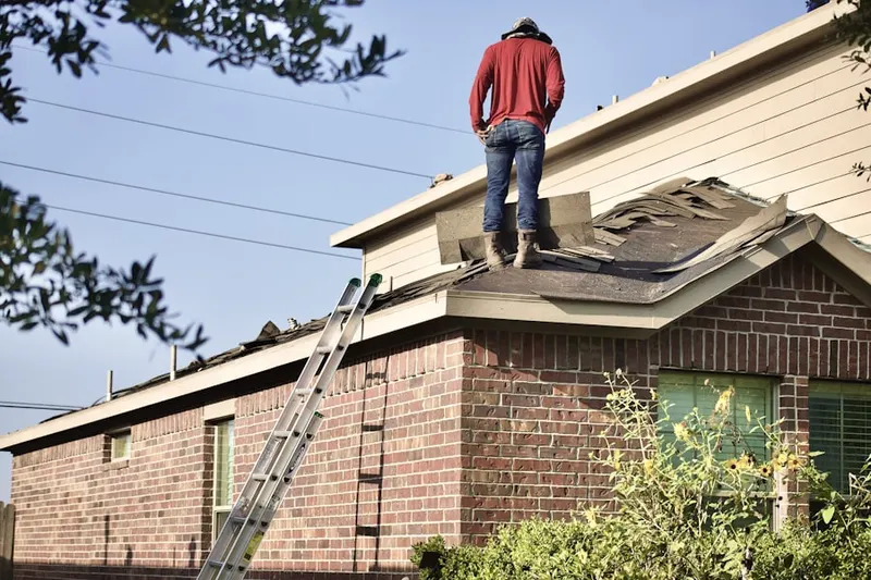 Professional roofer working on a residential roof in La Fetra
